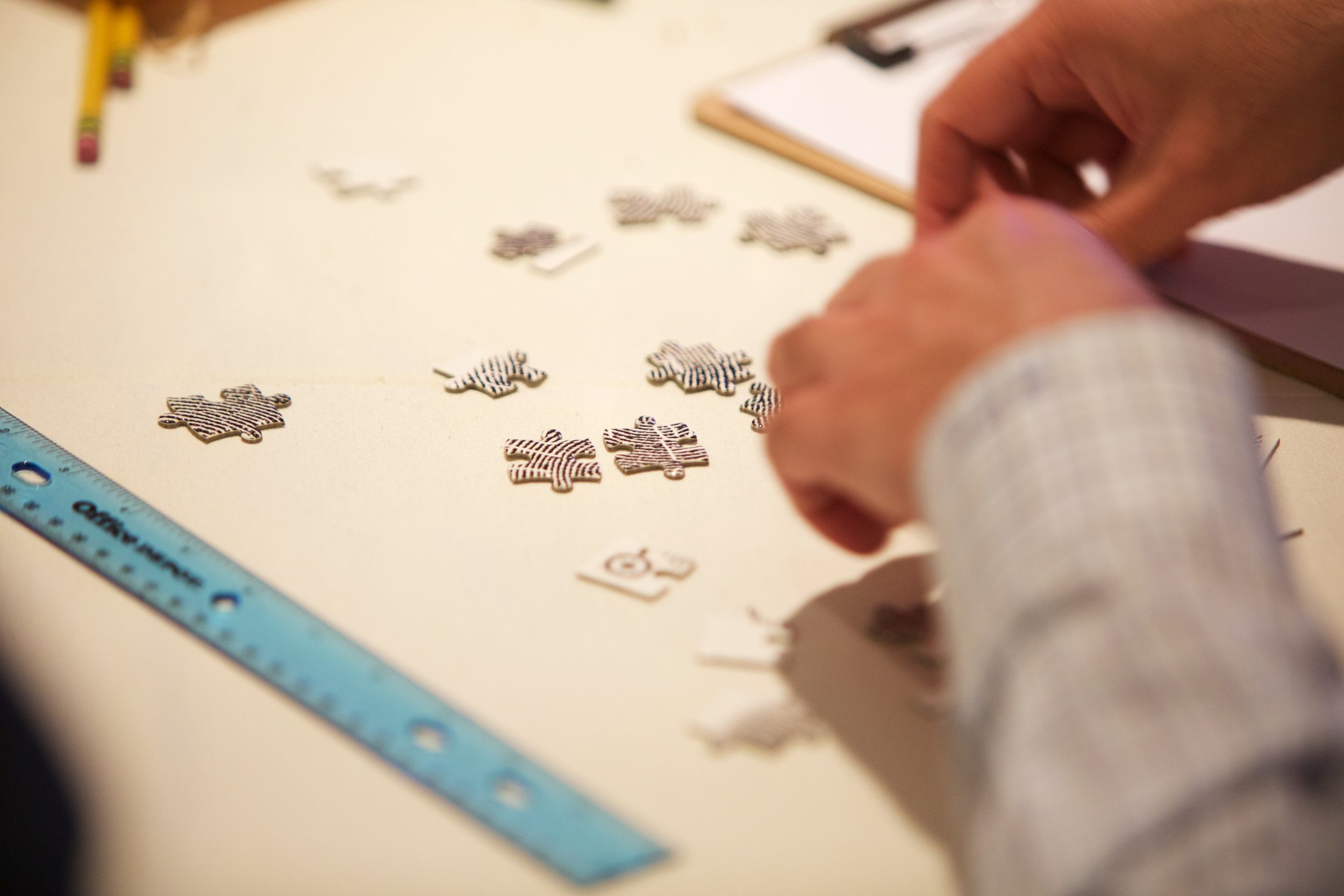 Person Putting Together Jigsaw Puzzle Pieces